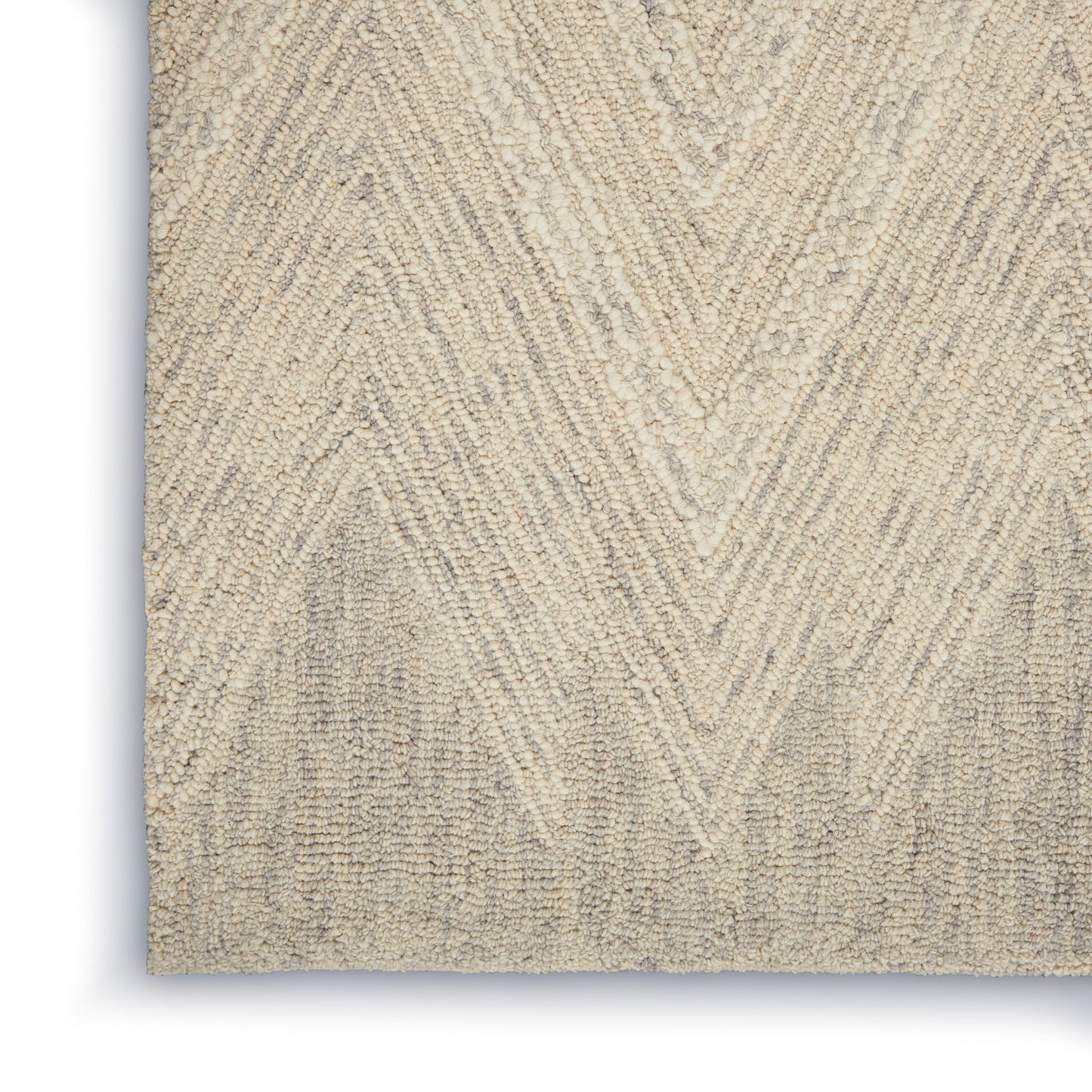 Beige textured area rug with chevron pattern and plush fibers; close-up view.