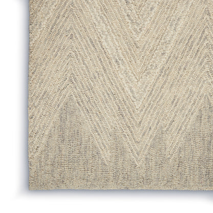 Beige textured area rug with chevron pattern and plush fibers; close-up view.