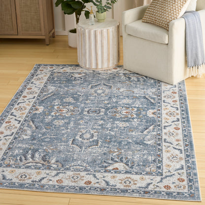 Blue oriental-style area rug with ivory border & floral medallions in a cozy living room.