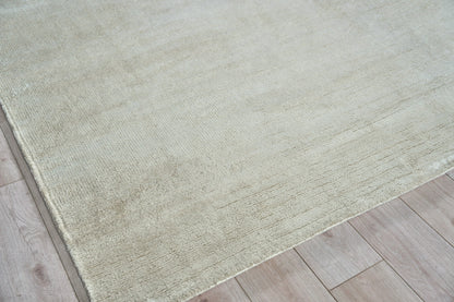 Beige-gray hand-knotted area rug on light wood floor, subtle texture, modern minimalist style.