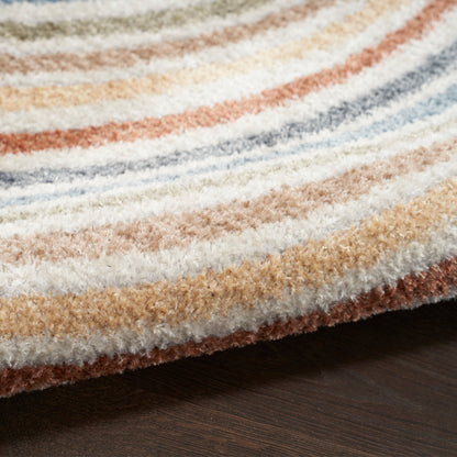 Close-up of striped plush rug in cream, beige, orange, blue and brown on dark wood floor.