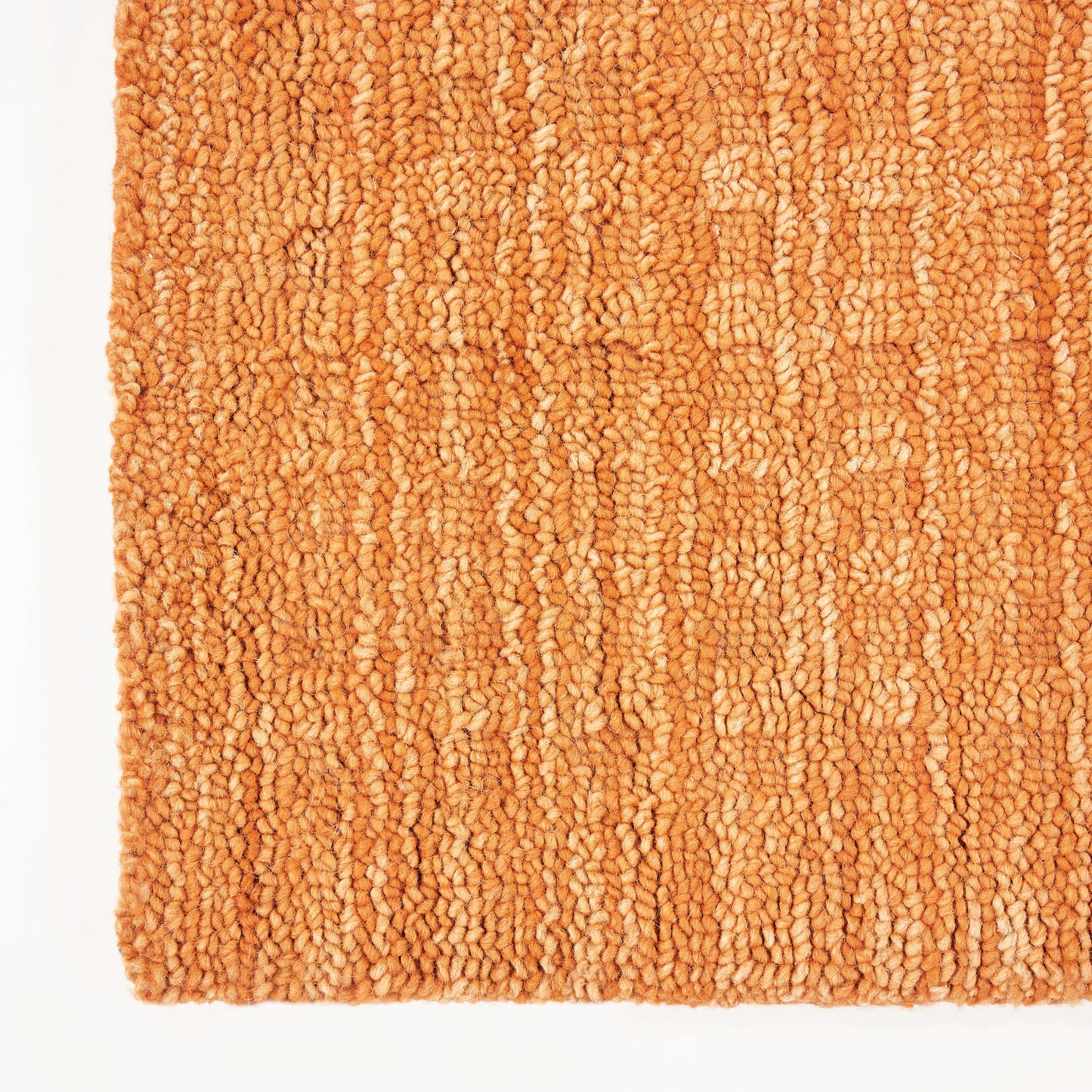 Close-up of orange loop-pile runner rug with chunky texture and warm terracotta tones.