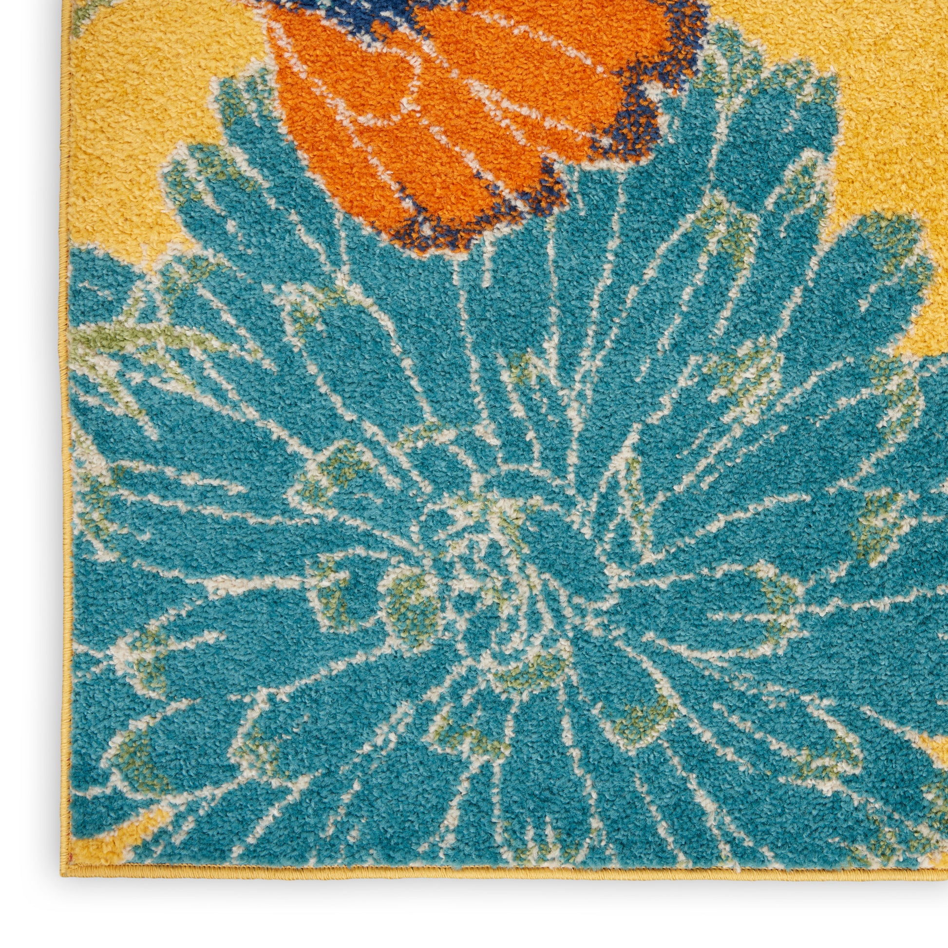 Teal floral rug with large blue petals and orange accents on a yellow background; shaggy tufted texture; 5' x 7'.