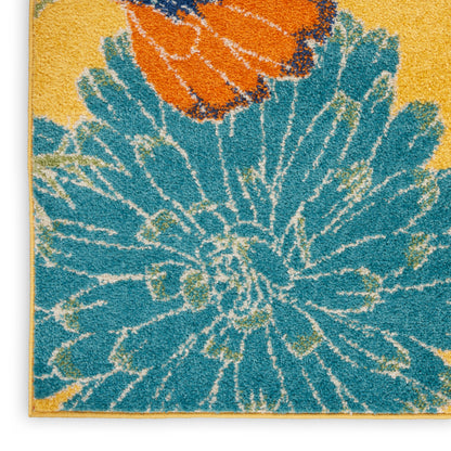 Teal floral rug with large blue petals and orange accents on a yellow background; shaggy tufted texture; 5' x 7'.