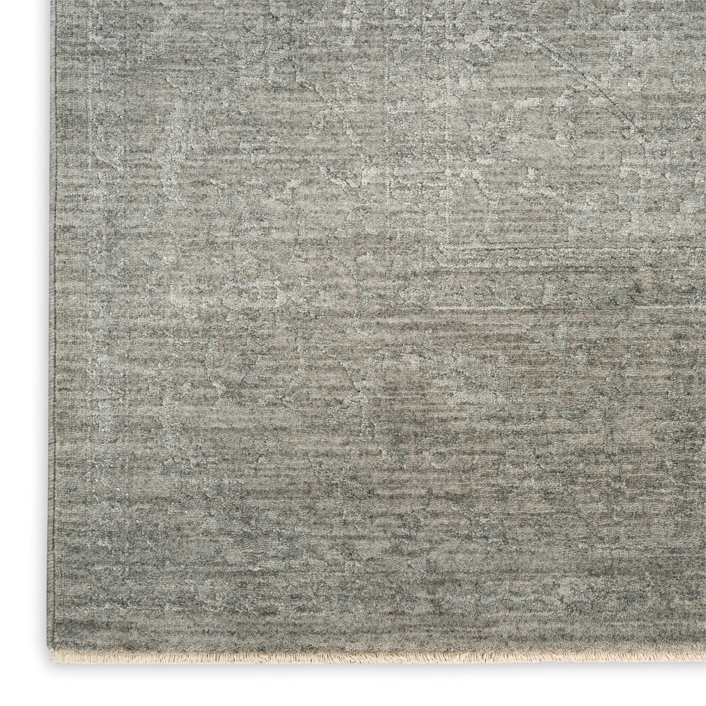 Rectangular gray distressed rug with a faded oriental pattern and short fringe along the bottom edge.
