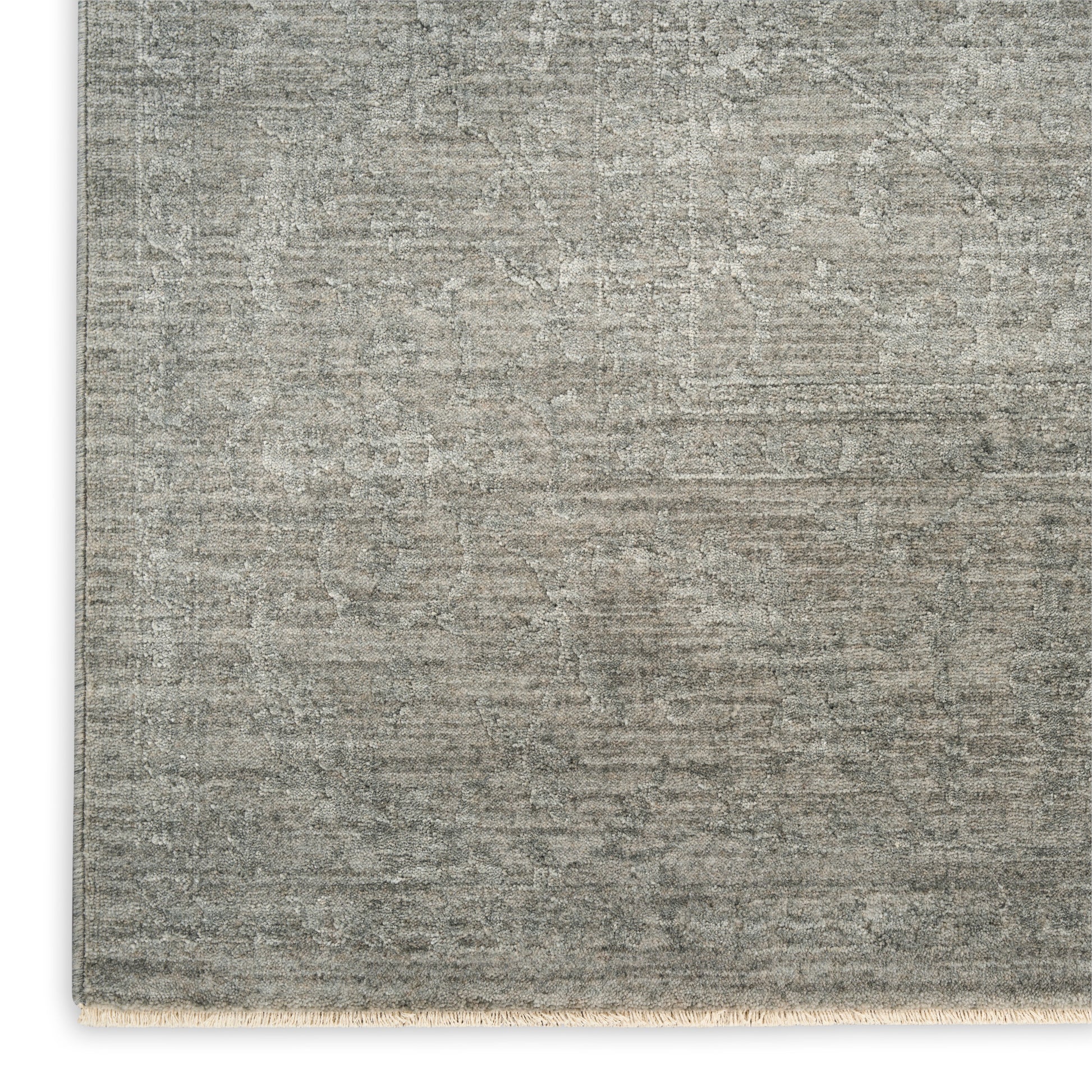 Rectangular gray distressed rug with a faded oriental pattern and short fringe along the bottom edge.