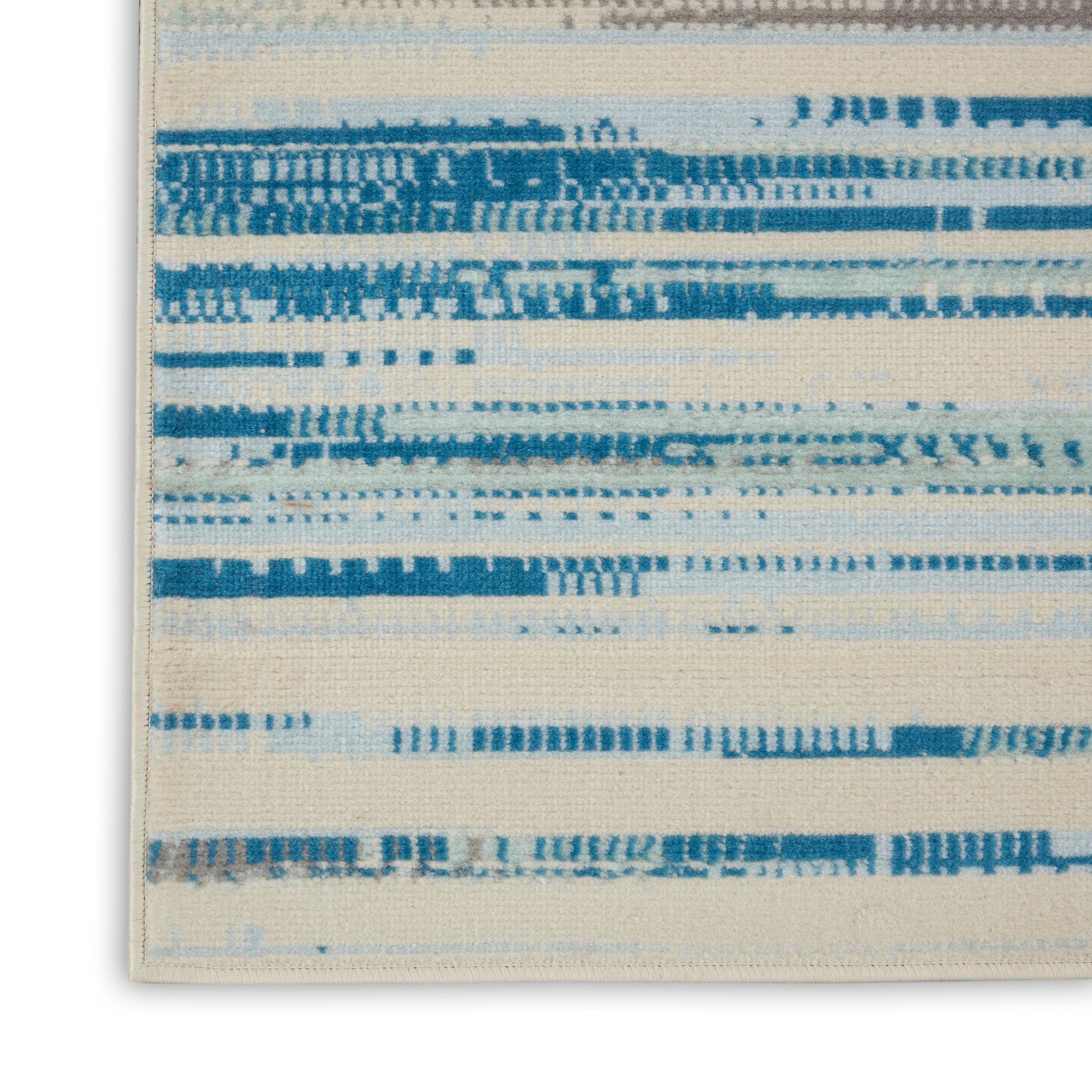 Cream and blue abstract striped rug close-up corner; woven texture with horizontal brushstroke bands.