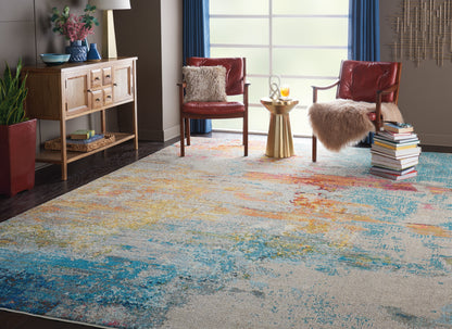 Abstract multicolor area rug in blue, teal, yellow and orange; modern living room with red leather chairs and fur throws.