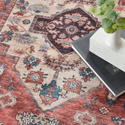 Colorful oriental rug with red, blue and beige patterns; white vase with green plant atop a black book.