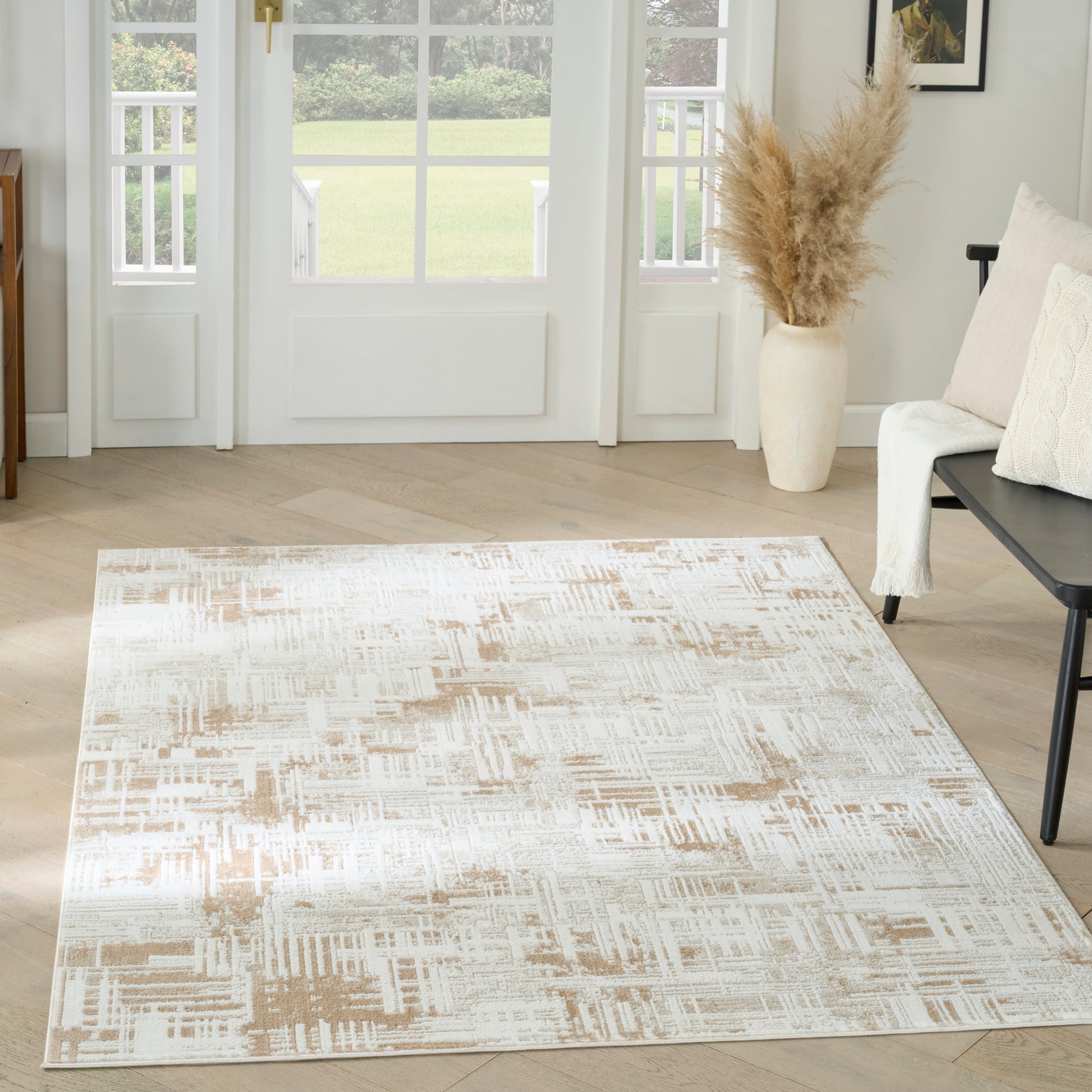 Neutral beige and ivory abstract area rug, rectangular, in a bright living room with pampas grass vase.