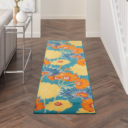 Long hallway runner rug with teal background and large yellow and orange tropical flowers; modern floral print.