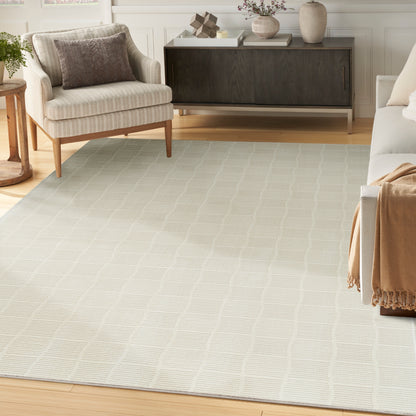 Light beige area rug with a subtle geometric lattice pattern in a modern living room.