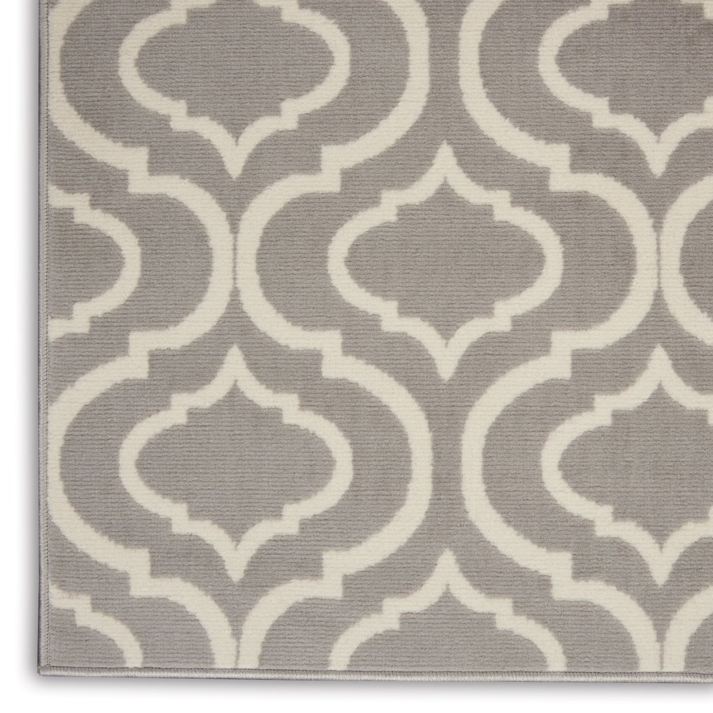 Gray rug featuring a white trellis geometric pattern, textured woven fabric, modern decorative style.