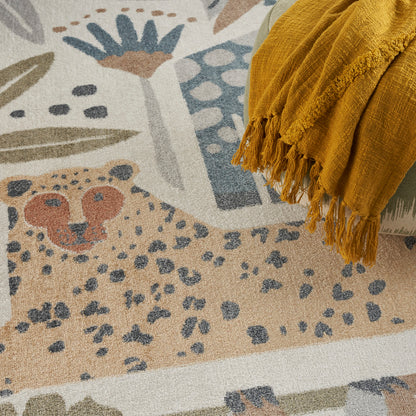 Beige abstract area rug with blue, teal & orange shapes; mustard yellow fringed throw draped along edge.