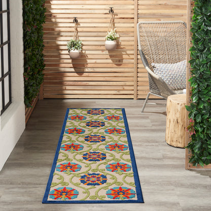 Beige runner rug with blue border and colorful floral medallions on a wooden porch with wicker chair and hanging planters