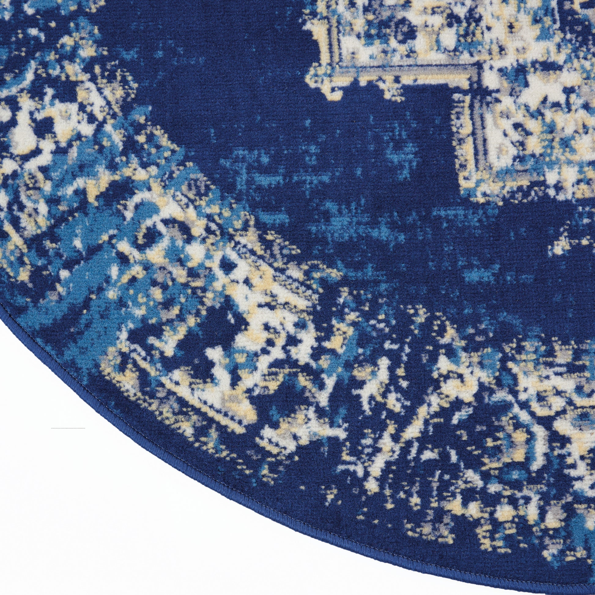 Round navy rug with abstract light-blue and beige distressed pattern.