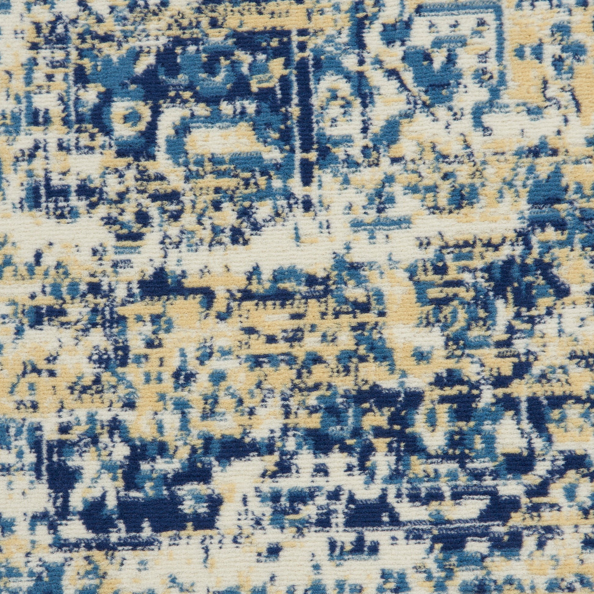 Close-up of blue and beige distressed rug pattern with abstract geometric motifs and woven texture.