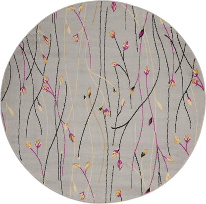 Round gray area rug with abstract black, pink and yellow twig-like lines and small leaves.