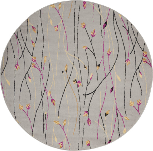Round gray area rug with abstract black, pink and yellow twig-like lines and small leaves.