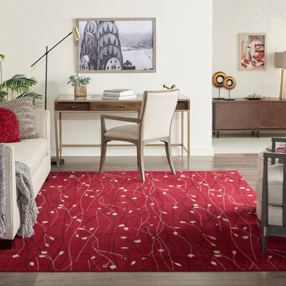 Red patterned area rug with ivory leaf motifs under a beige upholstered wooden desk chair in a modern living room.