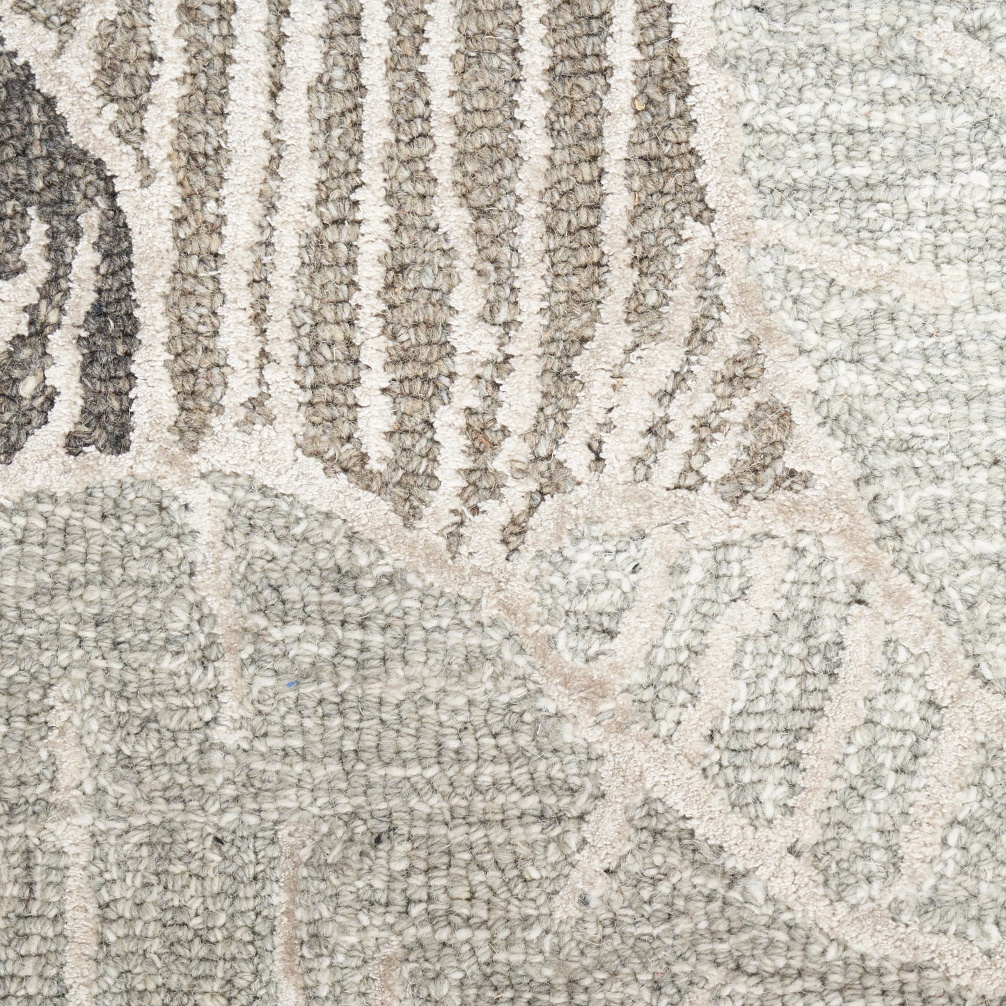 Cream, taupe and gray tufted area rug with geometric patchwork pattern and textured pile.