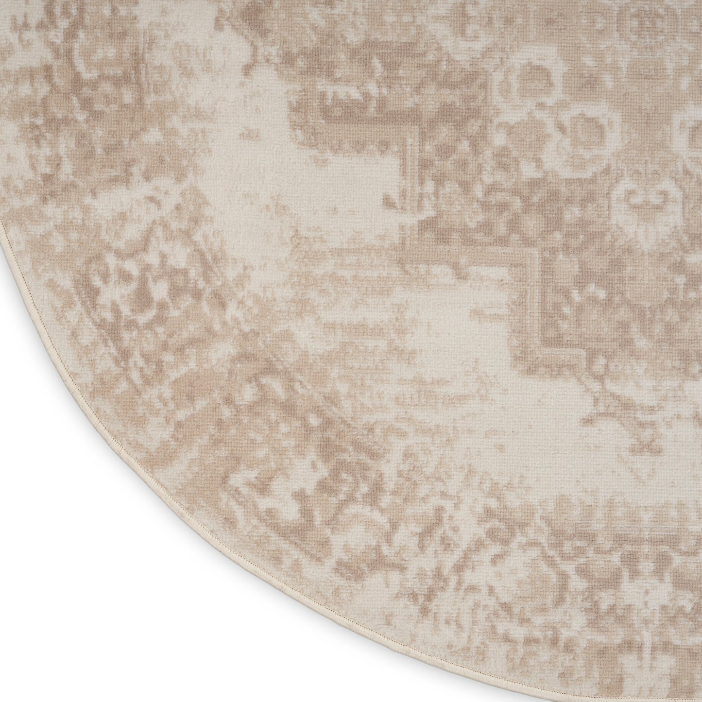 Beige round rug with distressed antique pattern in taupe, plush woven texture and light border.