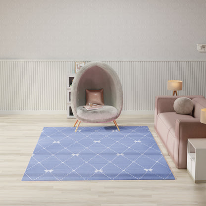 Gray fuzzy kids rug, 7' x 9', blue diamond pattern, placed in a bright modern living room with a pink sofa nearby.