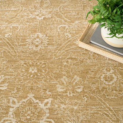 Beige floral patterned area rug with cream motifs and natural texture, paired with a wicker tray, plant and books.