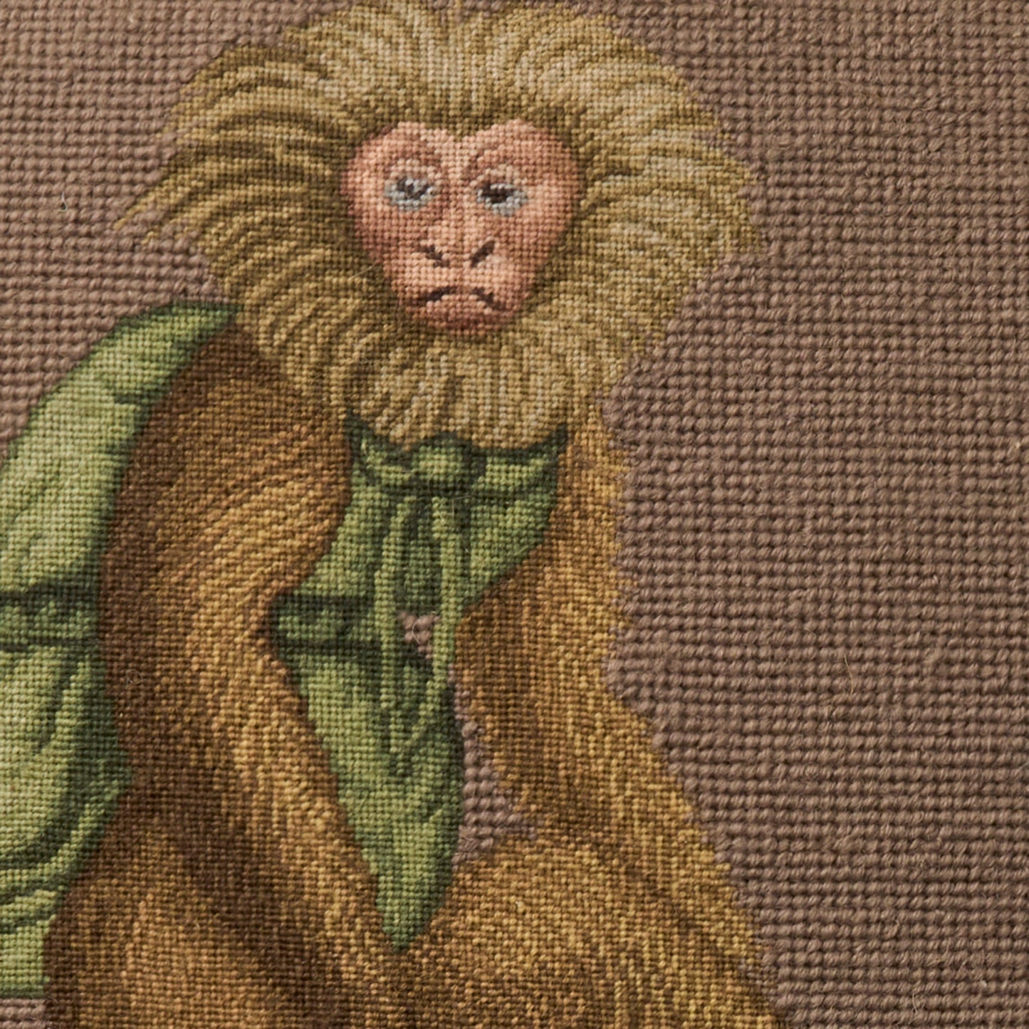 Woven rug featuring a heraldic lion motif in tan, gold, brown & green with a textured weave.