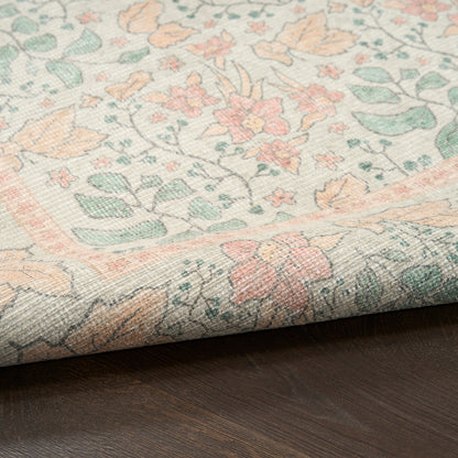 Pastel floral rug with peach, mint green, and beige tones; woven border design, rolled edge on dark wood floor.