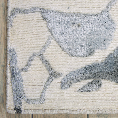Beige textured rug with a blue-grey bird silhouette, loop pile, cozy coastal style.