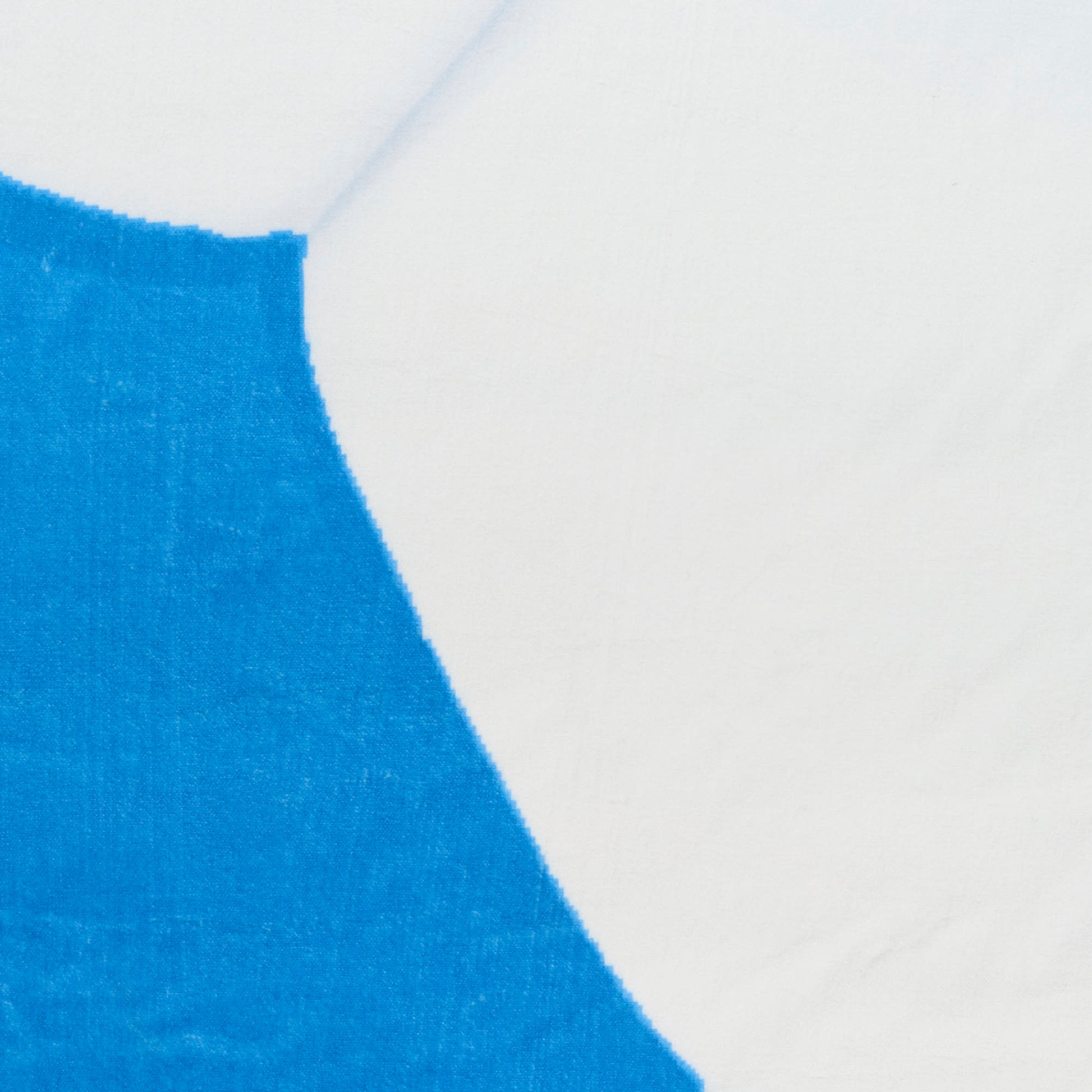 Close-up of vivid blue curved design on circular rug fabric with visible weave texture.
