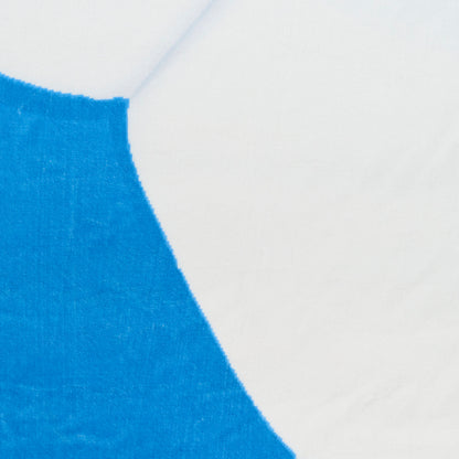 Close-up of vivid blue curved design on circular rug fabric with visible weave texture.
