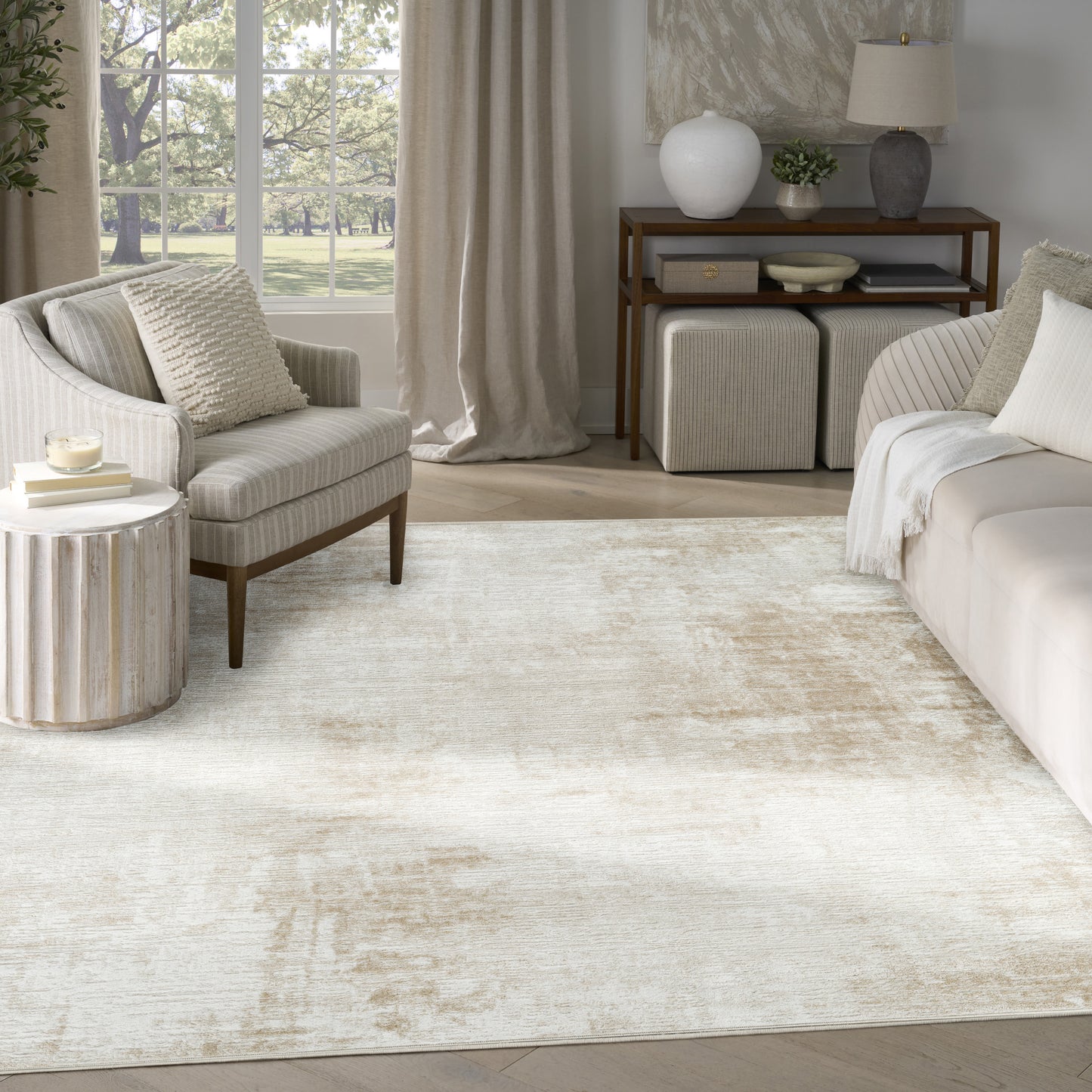 Rectangular neutral cream textured area rug with a subtle distressed pattern in a sunlit beige living room.