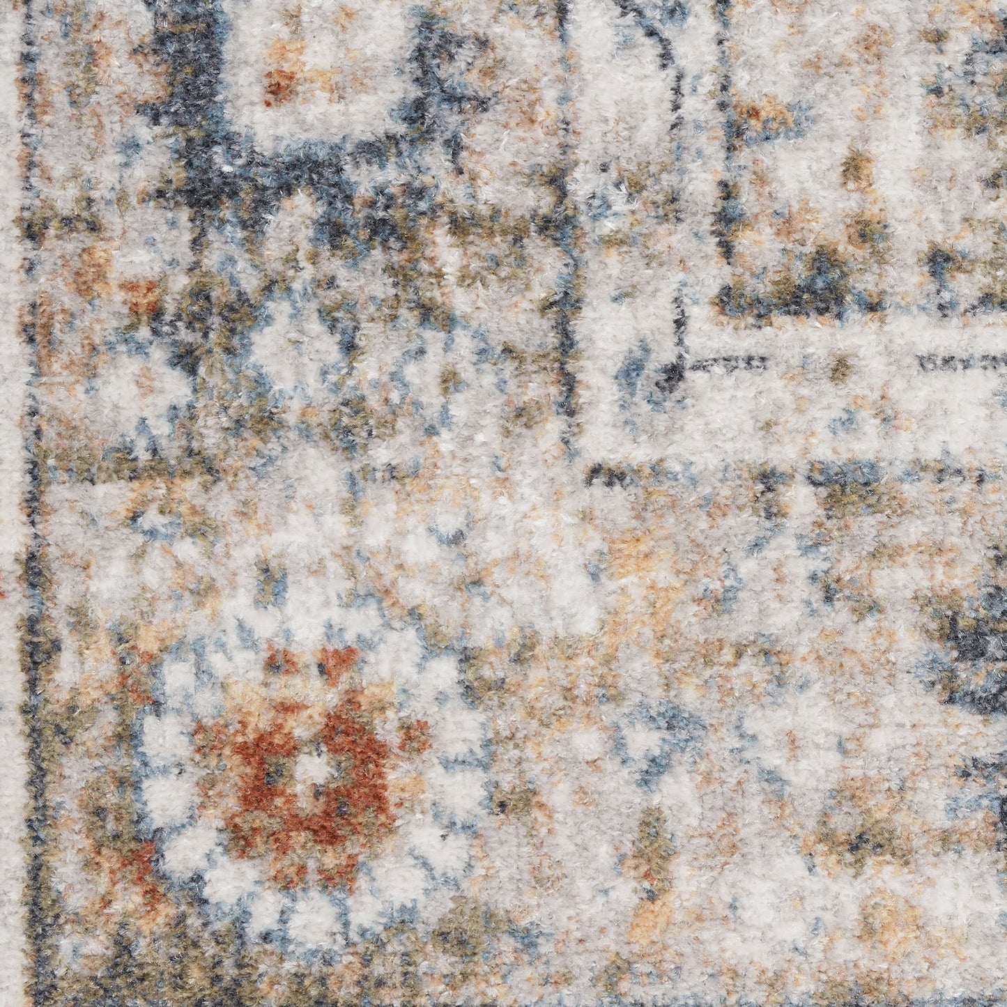 Distressed vintage-style area rug with abstract floral motifs in blue, ivory, beige and ochre hues.