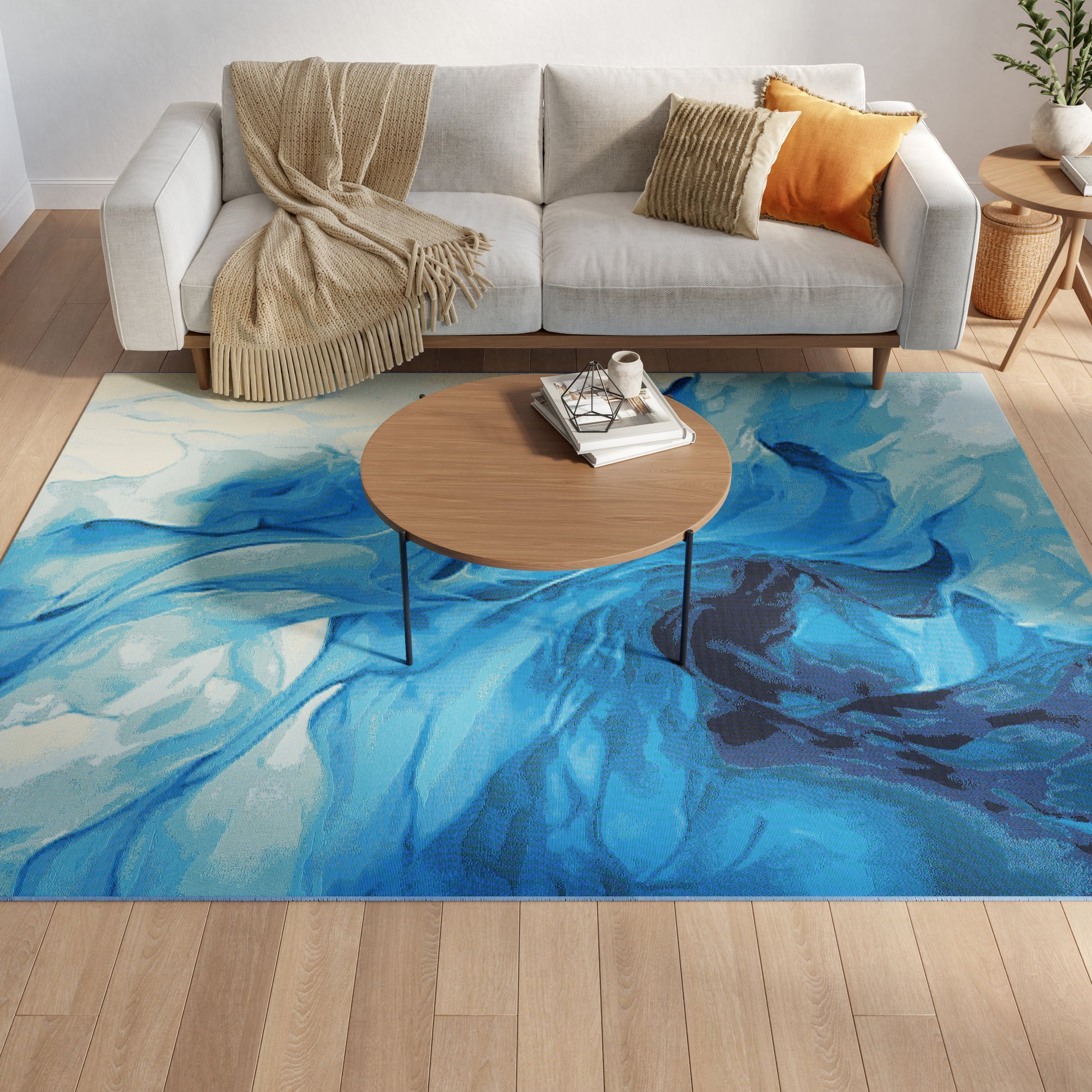 Cozy living room with blue abstract rug, round wood coffee table, light gray sofa, beige throw, and orange cushion.