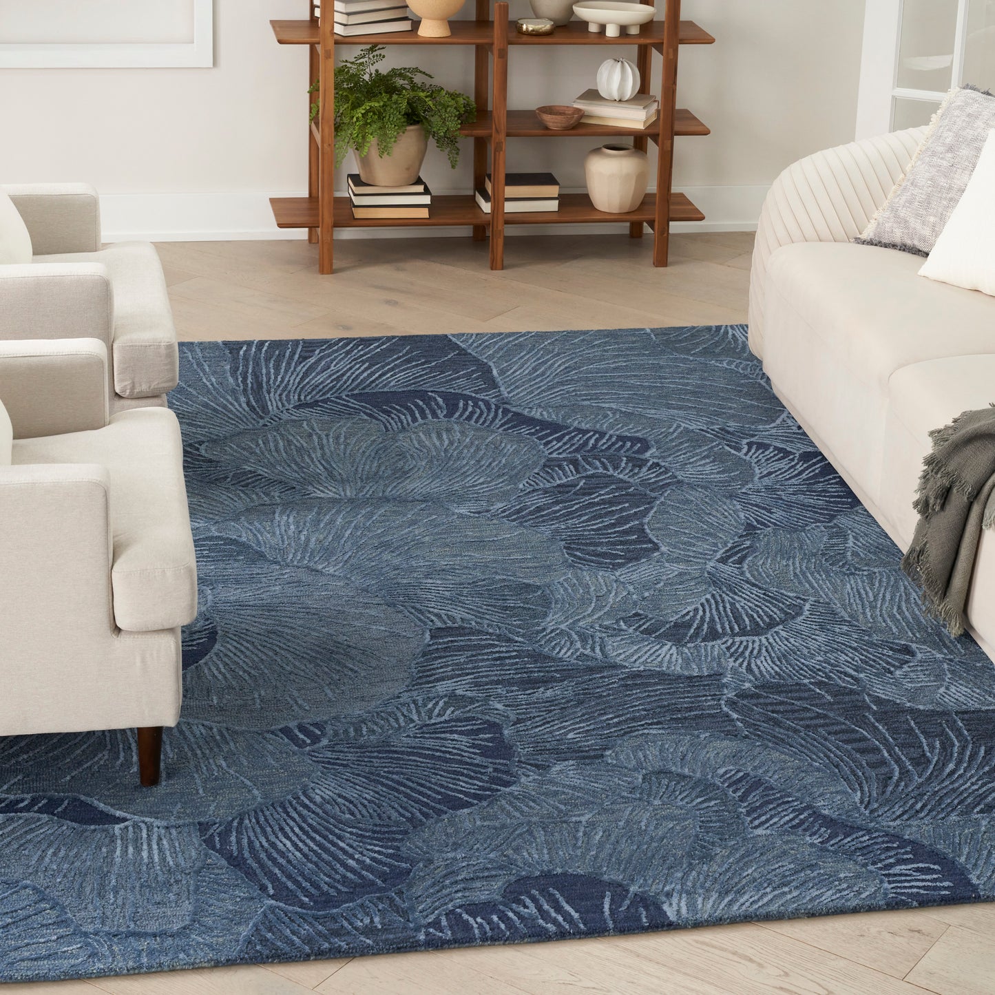 Blue textured area rug with large fern leaf pattern; soft, cozy underfoot for modern living rooms.