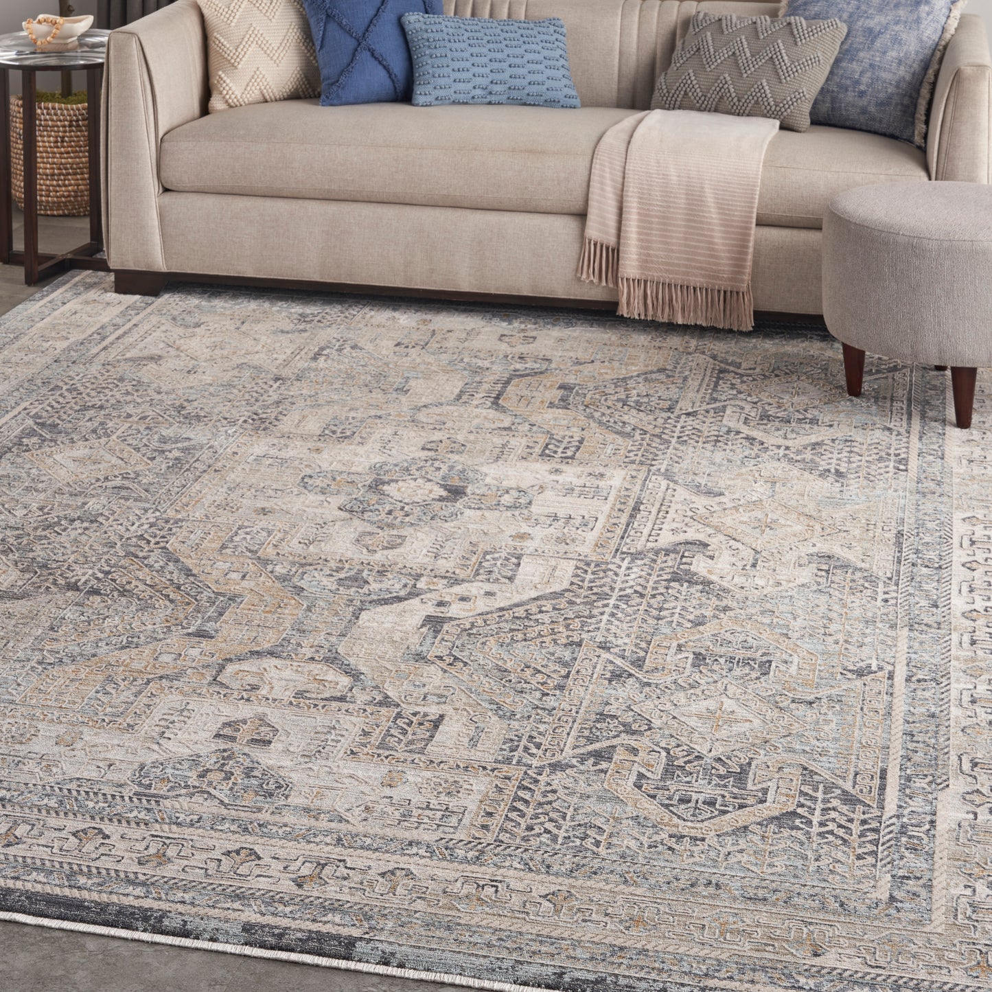 Blue-gray distressed oriental-pattern area rug with beige tones in a living room setting.