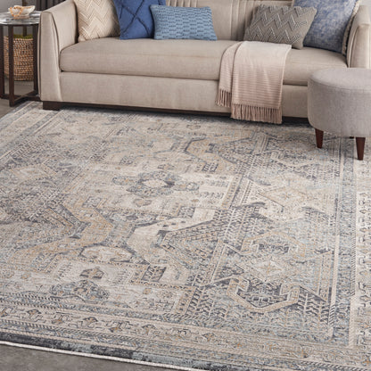 Blue-gray distressed oriental-pattern area rug with beige tones in a living room setting.