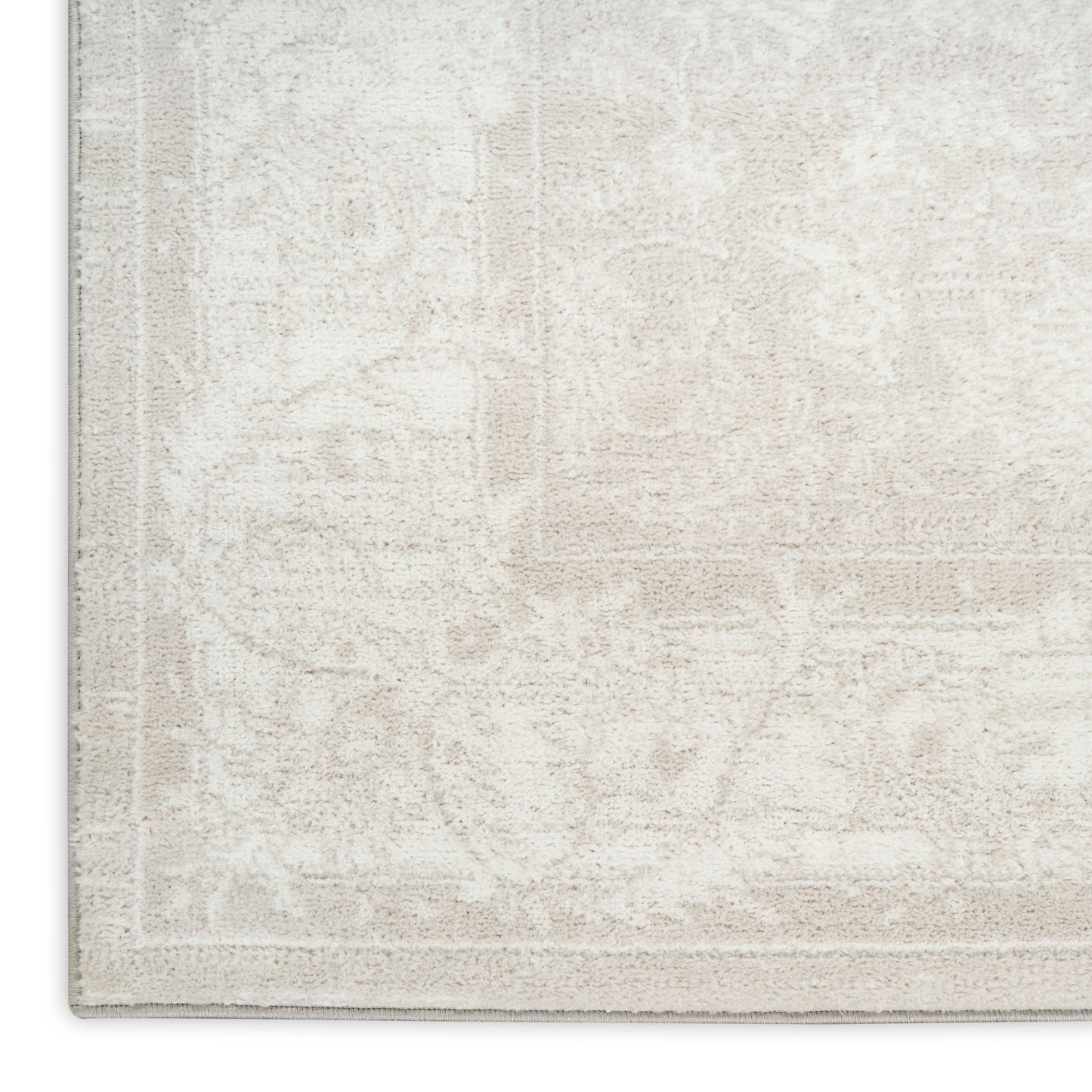 Beige area rug with subtle floral medallion pattern and light border; plush, neutral-toned, ideal for living room decor.