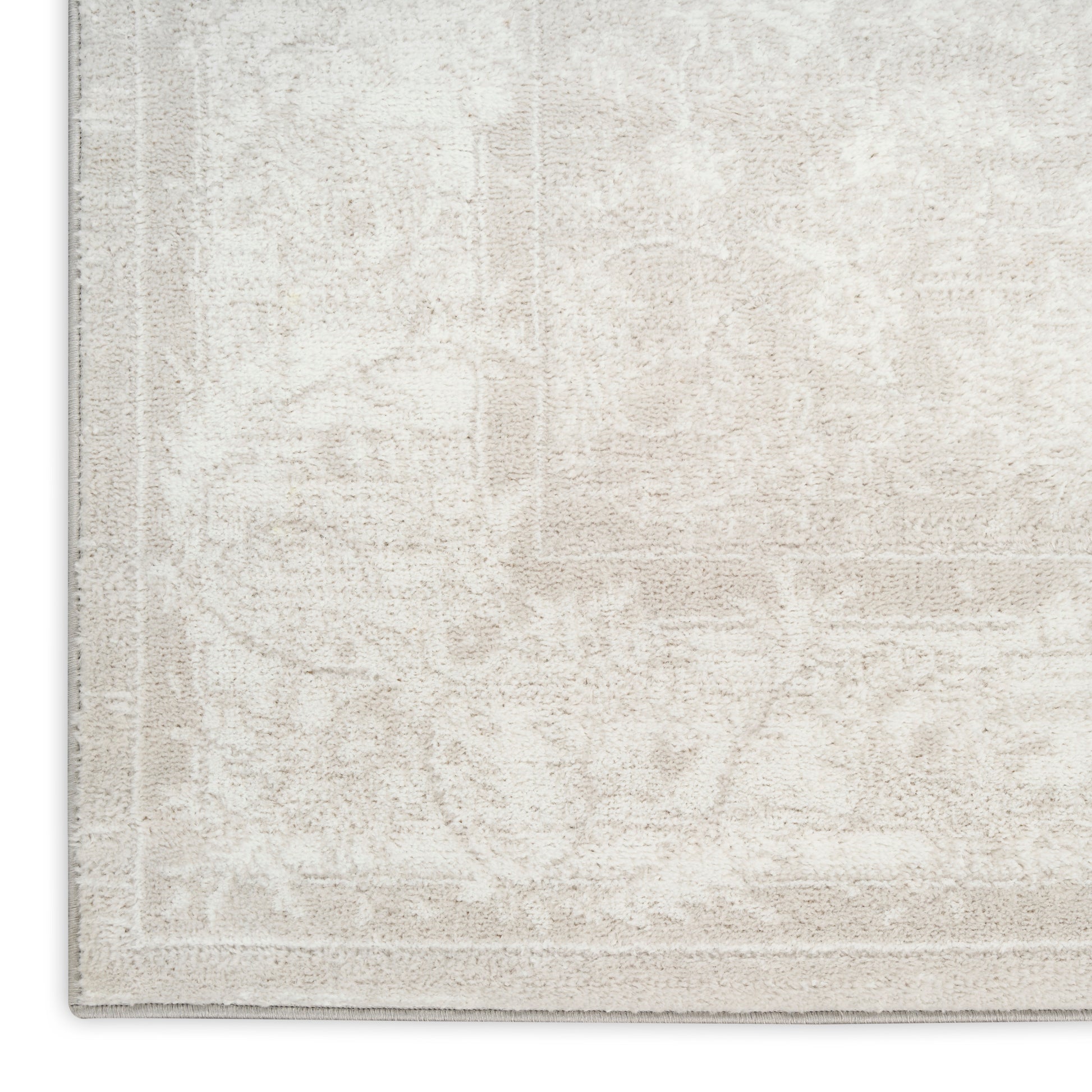 Beige area rug with subtle floral medallion pattern and light border; plush, neutral-toned, ideal for living room decor.