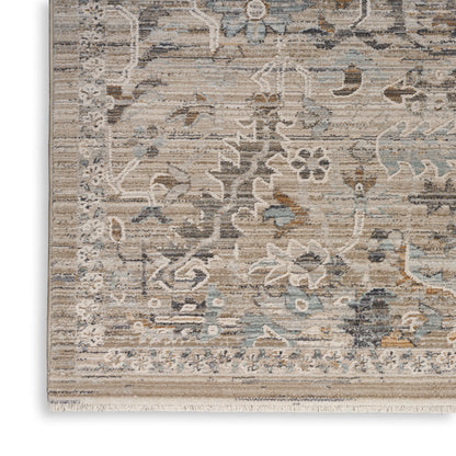 Distressed floral patterned area rug in beige, blue and gray with a fringed edge.