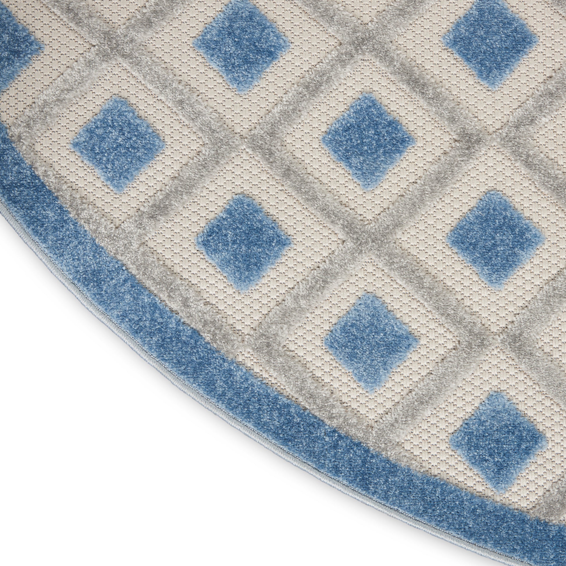 Circular rug with cream and blue diamond lattice pattern and blue border.