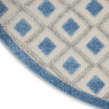 Circular rug with cream and blue diamond lattice pattern and blue border.
