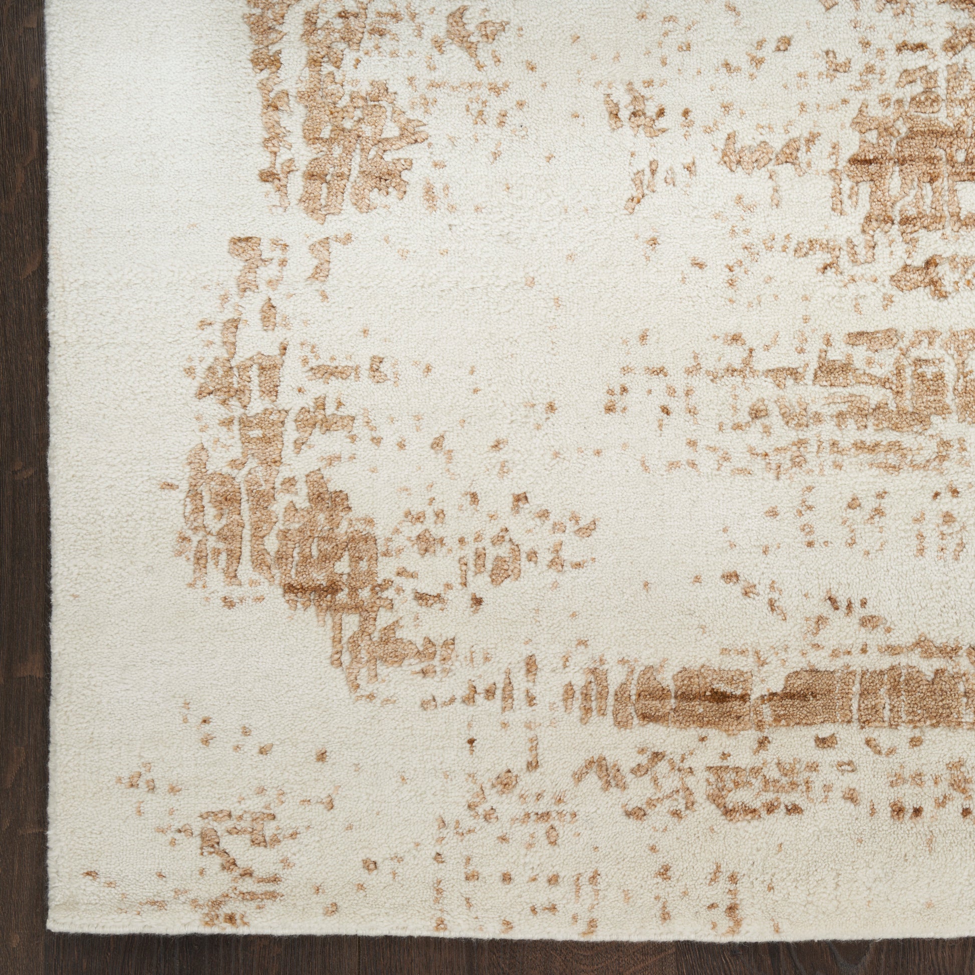 Rectangular cream area rug with tan-brown distressed pattern and dark brown left border.