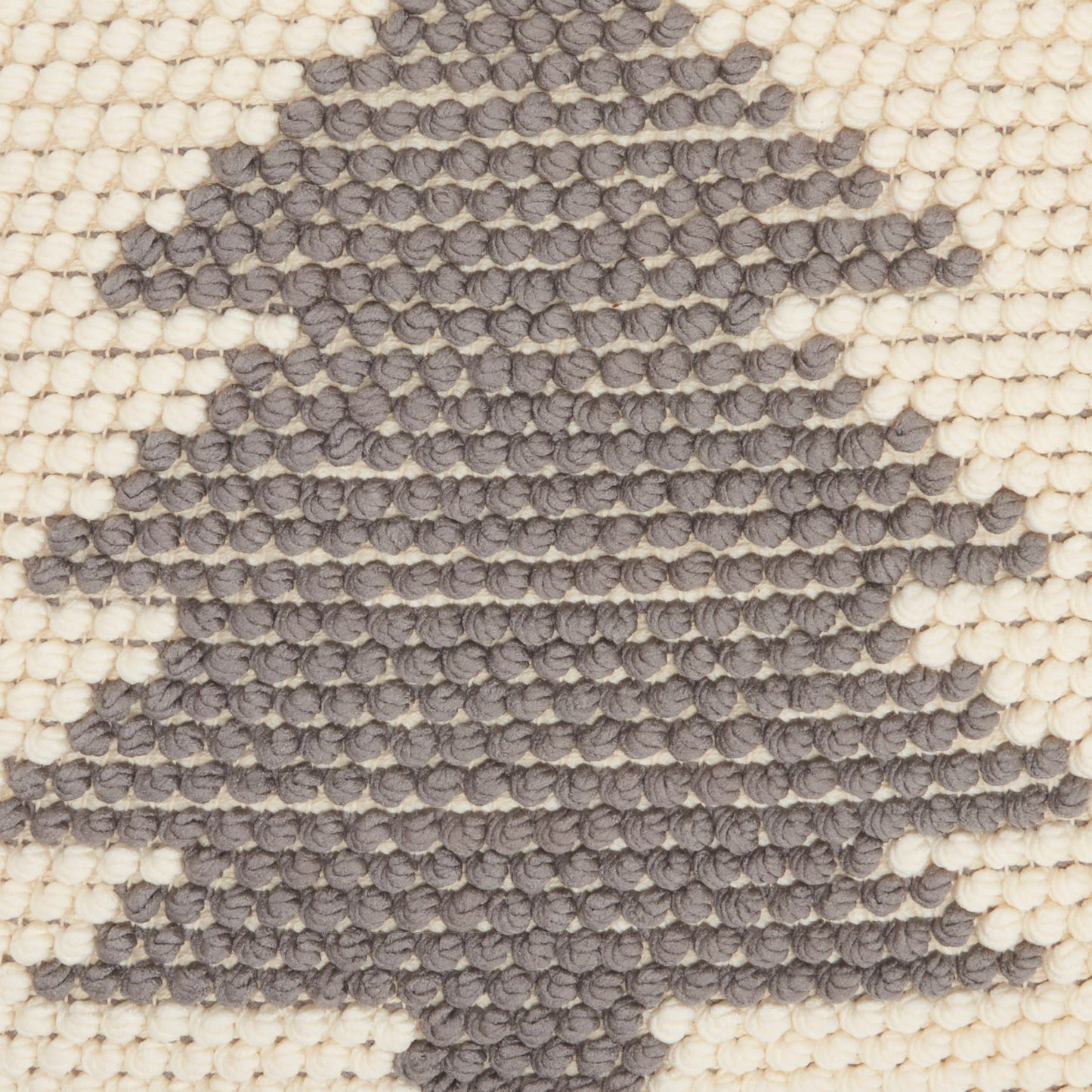 Cream woven rug with charcoal tree silhouette in chunky looped tuft texture.