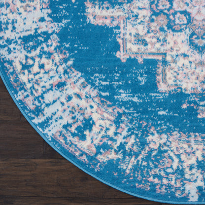 Round turquoise rug with pink/ivory distressed pattern, blue binding edge; cozy boho living room decor.