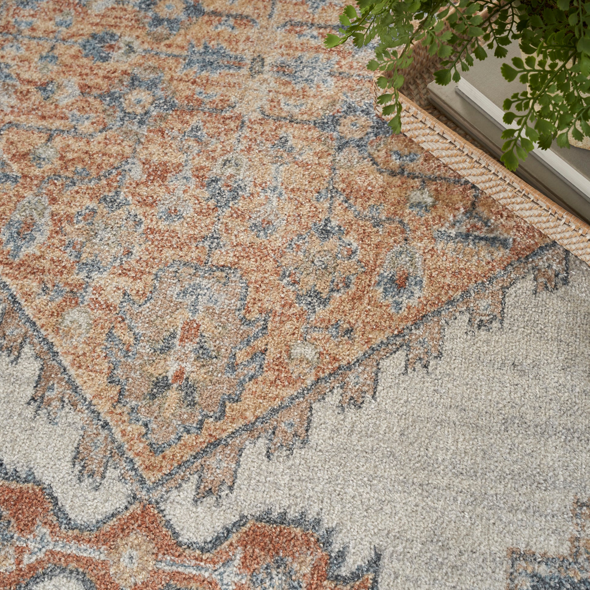 Rust orange, cream and navy blue distressed Oriental rug with fringed border and plush pile for living room decor.