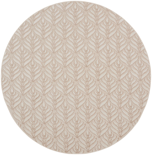 Round beige rug with subtle raised taupe leaf motif.