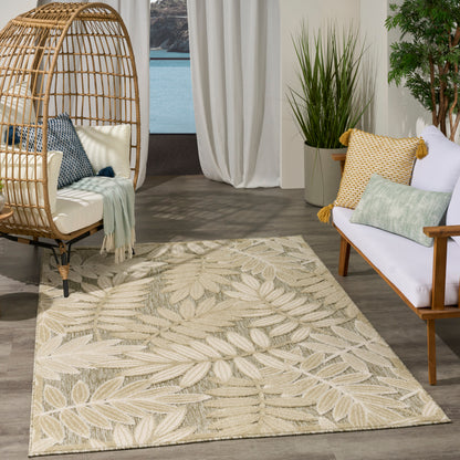 Beige leaf-pattern area rug in a coastal living room with a wicker egg chair, wooden sofa, throw pillows, and potted plants.